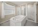 Elegant bathroom with soaking tub, walk-in shower, and marble tile at 9511 Tequila Sunrise Dr, Sarasota, FL 34241