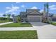 Two-story house with gray exterior, two-car garage, and landscaping at 9511 Tequila Sunrise Dr, Sarasota, FL 34241