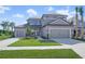 Two-story house with gray exterior, two-car garage, and landscaping at 9511 Tequila Sunrise Dr, Sarasota, FL 34241