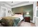 Main bedroom with green accent wall and wood furniture at 1021 Fernleaf Run, Bradenton, FL 34212