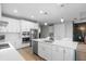 Modern kitchen with white cabinets, stainless steel appliances, and an island with a sink at 1021 Fernleaf Run, Bradenton, FL 34212