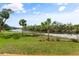 Peaceful waterfront view with lush landscaping and palm trees at 1021 Fernleaf Run, Bradenton, FL 34212