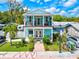 Two-story teal home with balcony, landscaping, and American flag at 1110 12Th W St, Bradenton, FL 34205
