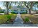 Beautiful light teal house with a grey roof, walkway, and well-manicured lawn at 1213 5Th W St, Palmetto, FL 34221