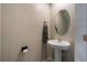 Clean and modern half bathroom with pedestal sink and oval mirror at 14350 Easy Goer St, Ruskin, FL 33573