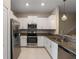 Modern kitchen with white cabinets, granite countertops, and stainless steel appliances at 14350 Easy Goer St, Ruskin, FL 33573