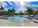Freeform community pool with palm trees and lounge areas at 14350 Easy Goer St, Ruskin, FL 33573