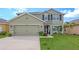 Two-story house with a green facade, landscaping, and a two-car garage at 15812 High Bell Pl, Bradenton, FL 34212