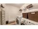 Bright laundry room with washer, dryer, and ample shelving at 15812 High Bell Pl, Bradenton, FL 34212