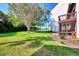 Spacious backyard with lush lawn, mature tree, and screened patio at 1626 Stickney Point Rd # 26-102, Sarasota, FL 34231