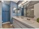 Updated bathroom with double sinks, a large shower, and blue walls at 1626 Stickney Point Rd # 26-102, Sarasota, FL 34231