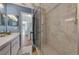 Bathroom with a walk-in shower and marble-style tile at 1626 Stickney Point Rd # 26-102, Sarasota, FL 34231