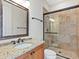 Bathroom boasts granite vanity, tiled shower, and framed mirror at 1810 Lincoln Dr, Sarasota, FL 34236