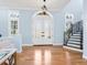 Elegant entryway with double doors, hardwood floors, and a curved staircase at 1810 Lincoln Dr, Sarasota, FL 34236