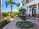 Elegant entryway with fountain, landscaping, and brick pavers at 1810 Lincoln Dr, Sarasota, FL 34236
