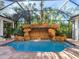 Relaxing pool area with a waterfall feature and a screened enclosure at 1810 Lincoln Dr, Sarasota, FL 34236
