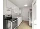Kitchen boasts stainless steel appliances, light wood floors, and white cabinetry at 21907 Cellini Ave, Port Charlotte, FL 33952