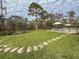 Landscaped backyard with stone pathway leading to a relaxing seating area at 22343 Panther Loop, Bradenton, FL 34202