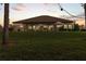 Landscaped backyard with a view of the house at dusk at 22343 Panther Loop, Bradenton, FL 34202