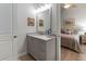 Spa-like bathroom features a gray vanity, marble countertop, and a view of the bedroom at 22343 Panther Loop, Bradenton, FL 34202