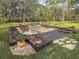 Stone firepit surrounded by wooden chairs in a landscaped area at 22343 Panther Loop, Bradenton, FL 34202