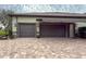 Two-car garage with dark gray doors and awning at 22343 Panther Loop, Bradenton, FL 34202