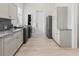 Laundry room with gray cabinets, granite counters, and full-size appliances at 22343 Panther Loop, Bradenton, FL 34202