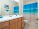 Clean bathroom with single vanity, shower/tub combo, and beachy decor at 236 Golden Harbour Trl, Bradenton, FL 34212