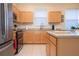 Kitchen with light wood cabinets, stainless steel appliances, and island at 236 Golden Harbour Trl, Bradenton, FL 34212