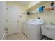 Laundry room with washer, dryer, utility sink, and shelving at 236 Golden Harbour Trl, Bradenton, FL 34212