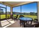 Screened patio with lake view and wicker furniture at 236 Golden Harbour Trl, Bradenton, FL 34212