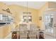 Dining area with glass table, white chairs, and access to a screened patio at 3001 Seawind Cir # 10C, Venice, FL 34293