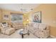 Bright living room with floral sofas, coffee table, and vaulted ceiling at 3001 Seawind Cir # 10C, Venice, FL 34293
