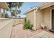 Small condo patio with tile flooring, potted plants, and a white metal chair at 3001 Seawind Cir # 10C, Venice, FL 34293