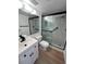 Modern bathroom with white vanity, walk-in shower, and wood-look flooring at 3231 Beneva Rd # 103, Sarasota, FL 34232