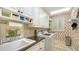 Laundry room with white cabinets and seashell wallpaper at 3310 Sabal Cove Ln, Longboat Key, FL 34228