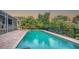 Refreshing pool and spa with brick patio, bordered by tropical foliage at 3310 Sabal Cove Ln, Longboat Key, FL 34228
