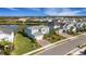 Aerial view of a light blue home with a lake view and lush landscaping at 3431 Chestertown Loop, Bradenton, FL 34211