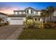 Two-story house with a three car garage and well manicured lawn at 3431 Chestertown Loop, Bradenton, FL 34211