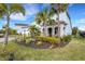 Two-story house with a stone facade, lush landscaping, and palm trees at 3431 Chestertown Loop, Bradenton, FL 34211
