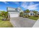 Two-story house with a three car garage, paver driveway, and palm trees at 3431 Chestertown Loop, Bradenton, FL 34211