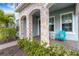 Inviting front porch with stone columns, a teal chair, and neatly landscaped area at 3431 Chestertown Loop, Bradenton, FL 34211