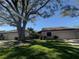 Exterior view of a charming villa with a lush green lawn and mature trees at 3725 Glen Oaks Manor Dr, Sarasota, FL 34232