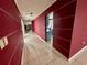 Long hallway with red walls and tile flooring, leading to other rooms at 3725 Glen Oaks Manor Dr, Sarasota, FL 34232