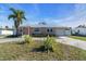 Tan single story home with coral colored door and palm trees at 524 Palm Ave, Ellenton, FL 34222