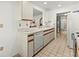 Efficient kitchen with light cabinets, dishwasher, and view into hallway at 5697 Sheffield Greene Cir # 51, Sarasota, FL 34235
