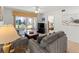 Living room with gray sofas, coffee table, TV, and view into bedroom at 5697 Sheffield Greene Cir # 51, Sarasota, FL 34235