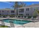 Community pool with ample lounge chairs and patio tables at 5697 Sheffield Greene Cir # 51, Sarasota, FL 34235