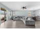 Open living room featuring gray sectional sofa and wood-look floors, leading to backyard at 7308 Tangle Bend Dr, Gibsonton, FL 33534