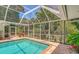 Relaxing screened-in pool and patio area with lush landscaping at 7331 Westmoreland Dr, Sarasota, FL 34243